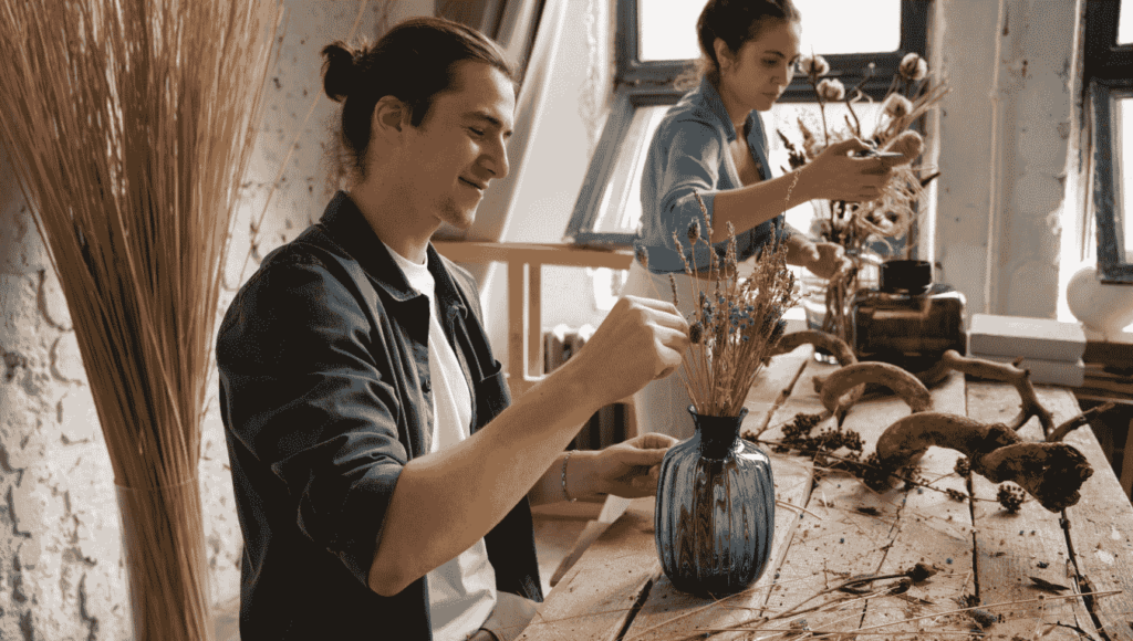 Artists working in an eco-conscious studio using sustainable materials like recycled paper and plant-based paints.